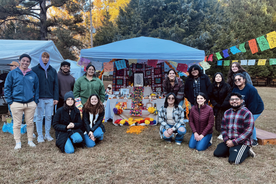Students in Introduction to Latino/a Studies gather in front of their ofrenda